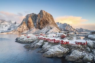 Rorbuer fishing huts in front of snow-covered mountains in winter, Hamnøy, Moskenesøy, Lofoten,