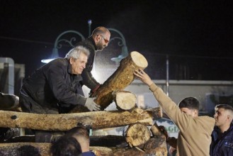 Men working together at night to build a large pile of wood for a fire, Easter fire Psinthos, Holy