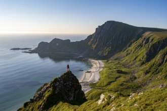 Climber on a rock, view of picturesque coastal landscape, steep coast with peak Måtind or Måtinden,