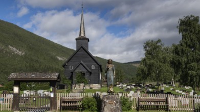 Wooden church in Sel with a cemetery and a statue of Kristian Lavranstochter, the main character