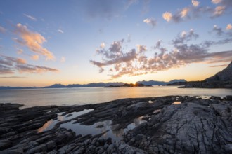 Clouds reflected in a small pond on a rocky coast, coastal landscape at sunset, Henningsvær,
