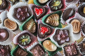 Top view and close-up of hand made mixed flavor fancy fine delicious chocolates in opened chocolate