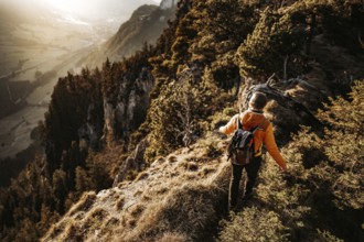 Hiker in the Allgäu at sunset in spring on the Zirmgrat near Pronten in the Allgäu