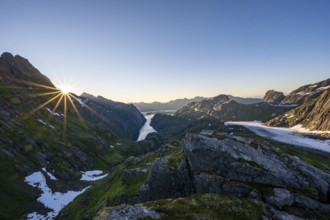 Picturesque mountain landscape at sunrise with sun star, fjord Trollfjord and Raftsund, hike to