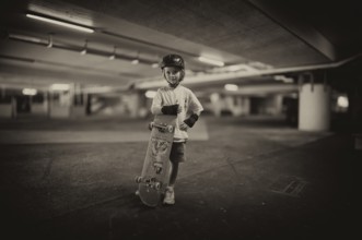 Boy, blonde, 6 years, posing with skateboard, crash helmet, protective clothing, subway, urban,