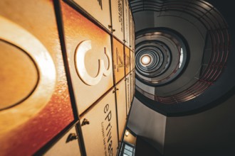 Dramatic view upwards through a spiral staircase with warm light, SPRINKENHOF, Hamburg, Germany,