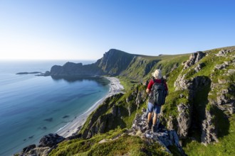 Mountaineer in front of view of coastal landscape, steep coast with summit Måtind or Måtinden,