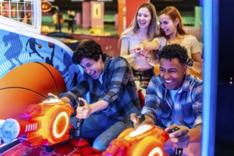 Young adults enjoying time together while playing arcade games in a vibrant bowling alley, filled