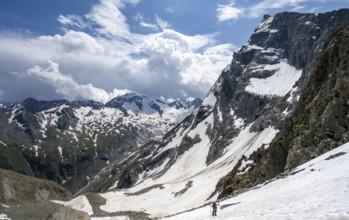 Mountaineer hiking in a snowfield, Nördliche Mörchnerscharte, behind mountain peak Kleiner Mörchner