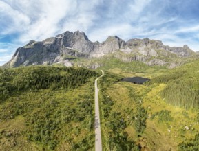 Panoramic aerial view of road in mountain scenery, passing lakes and meadows, road from E10 to