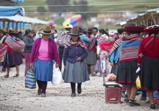 Peruvian woman with traditional skirts and hats at the indigenous market in Chinchero, Cusco