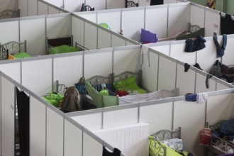 Temporary rooms with beds are set up in an emergency shelter for refugees on 9 December 2015 in a
