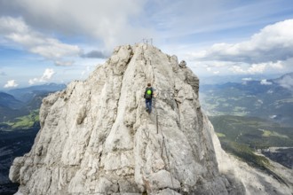 Mountaineer on a narrow rocky ridge on a steel cable, Watzmann crossing to Watzmann Mittelspitze,