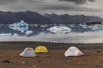 Tents in front of glacier lagoon, icebergs, camping, mountains, cloudy, winter, Jökulsarlon,