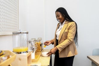 Smiling businesswoman serving breakfast from hotel buffet during business trip, enjoying orange