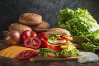 A burger with fresh vegetables on a rustic board with ingredients in the background