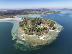 Aerial view of the island of Mainau at low tide with spring-like vegetation, on the horizon the
