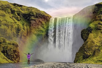 Child in front of Skogar waterfall rainbow Iceland