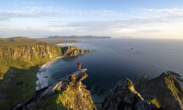 Evening mood, mountaineer standing on a rocky outcrop on the summit of Måtind, view of coastal