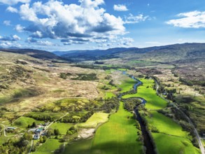 Farms and Mountains over River Dochart and Road A85 from a drone, Perthshire, Scotland, UK