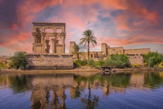 Incredible orange sunrise at the temple of Philae, a Greco-Roman construction seen from the Nile
