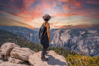 A young woman trekking at Sentinel Dome Lookout in Yosemite National Park looking at El Capitan