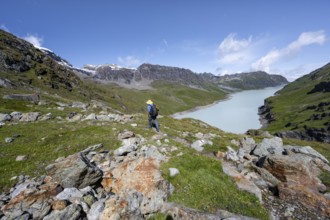 Mountaineer on hiking trail in front of Lac des Dix reservoir, Valais Alps, Valais, Switzerland,