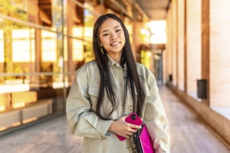 Portrait of a female beauty chinese cute university student standing with mobile phone and laptop