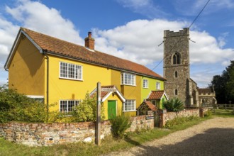 Historic cottages next to village parish church of All Saints, Rede, Suffolk, England, UK