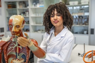 Confident medical student learning human anatomy using anatomical model in a university laboratory