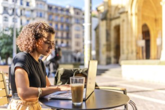 Horizontal photo with copy space of a Young arab entrepreneur working with laptop in sidewalk