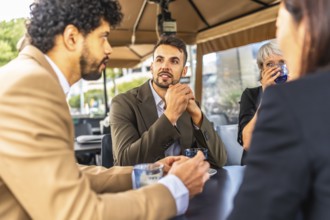 Business coworkers talking while drinking coffee during work break at cafeteria