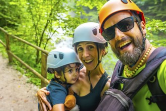 Happy family wearing helmets, taking a selfie at the vintgar gorge, a wooden footbridge in bled,