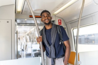 Smiling and casual african businessman travelling by metro in the city