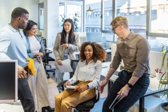 Diverse colleagues engaging in teamwork, sharing ideas, and working together in a modern coworking