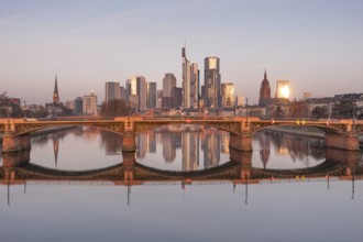The Frankfurt bank skyline is reflected in the Main River in the morning, shortly after sunrise,