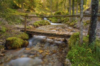 View of a rustic wooden bridge leading over a torrent, long exposure, Dolomites, Puez-Geisler