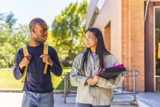 Multi-ethnic african and chinese exchange students talking walking along university campus