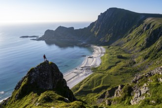 Climber on a rock, view of picturesque coastal landscape, steep coast with peak Måtind or Måtinden,