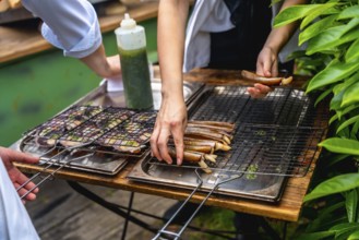 Chefs grilling seafood in an outdoor setting, preparing dishes for a wedding reception, with fresh