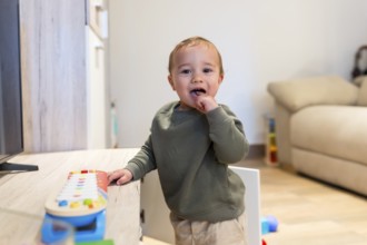 Curious toddler engaging with colorful musical toy, exploring sounds and developing musicality in a