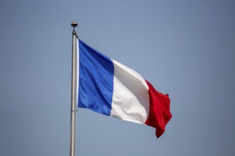 French flag in front of a blue sky
