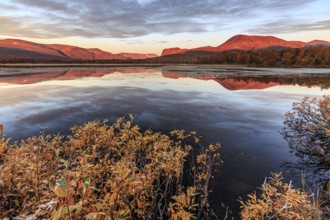 Mountains reflected in lake, autumn colours, cloudy mood, morning light, dawn, Nikkaluokta,