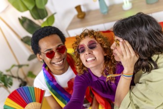 Multi-ethnic and non binary friends having fun together celebrating lgbt pride at home