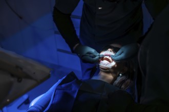 Dentist applying whitening gel on patient's teeth, enhancing oral health and creating a radiant,