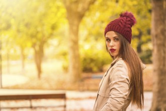Outdoor atmospheric lifestyle portrait of a beautiful young woman in a forest in autumn
