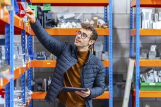 Engineer using tablet in the stock room of a computer numeric control modern factory