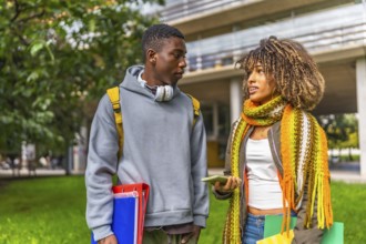 Two young and multiracial students chatting in the university campus