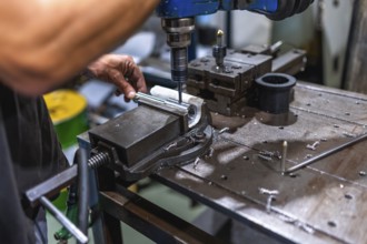 Close-up of male worker working using threading machine in cnc metal workshop
