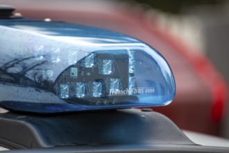 Symbolic image of a police operation: close-up of a flashing blue light on a police car